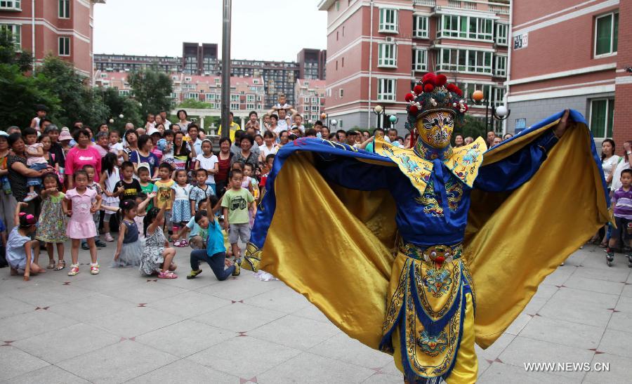 Citizens watch performance during a cultural activity at a community in Tongzhou District, Beijing, capital of China, June 18, 2013. (Xinhua/Bu Xiangdong)