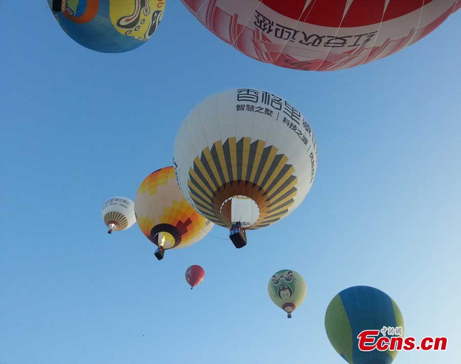 Air balloons fly over Evergreen Garden in Haikou, South China's Hainan Province, June 18, 2013. An air balloon competition kicked off on Tuesday, in which contestants are requested to fly across the Qiongzhou Strait from Haikou and reach a designated place in Xunwen County in the neighboring Guangdong Province. (CNS/Wang Xinli)