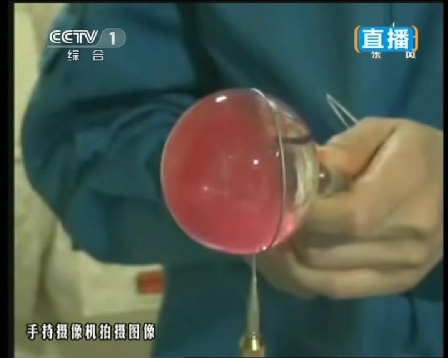 This TV grab taken on June 20, 2013 shows female astronaut Wang Yaping, one of the three crew members of Shenzhou-10 spacecraft, injecting red paint into a water ball in space during a lecture to students on Earth aboard China's space module Tiangong-1. A special lecture began Thursday morning, given by Wang Yaping aboard China's space module Tiangong-1 to students on Earth. (Xinhua)