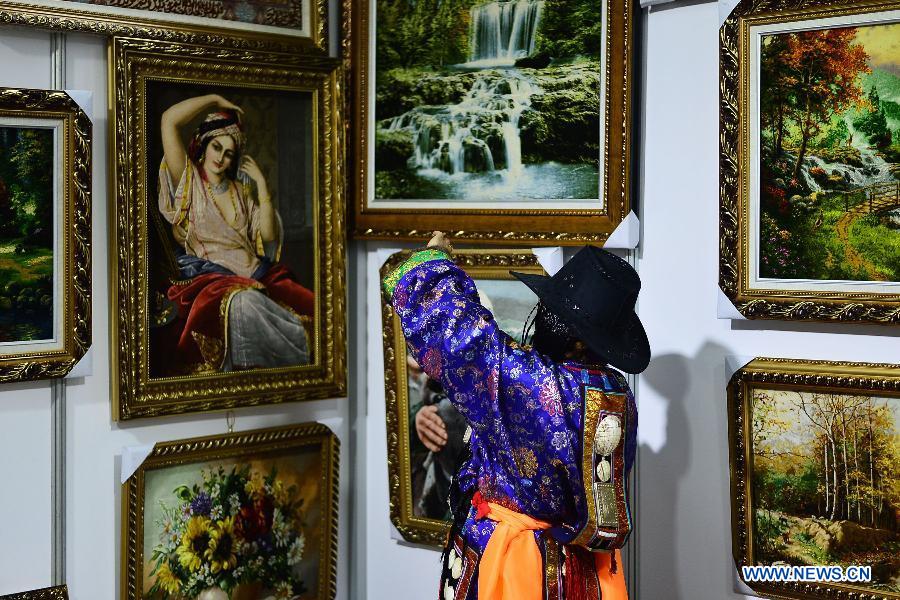 A visitor takes a photo of decorational carpets at a Tibetan carpet exposition in Xining, capital of northwest China's Qinghai Province, June 20, 2013. Opened Thursday, the exposition attracted some 110 exhibitors from 9 countries. (Xinhua/Wu Gang)