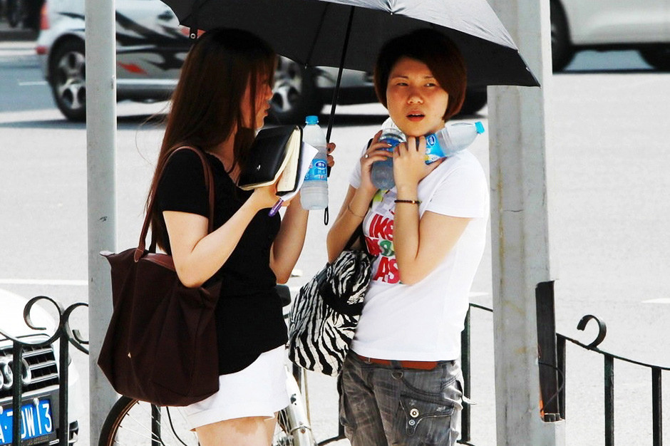 Pedestrians in Shanghai use ice water to cool down on June 17, 2013. (Photo/Xinhua)