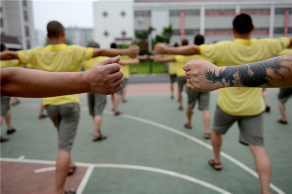 Addicts do group exercises at a drug rehabilitation center in Anhui province, June 19, 2013. "The days when I took drugs, I changed a lot in temper and became crusty and paranoid. After a year of drug control in the center, I've shrugged off many bad habits and become much better in body and mentality. Now I'm eager to find a job in my hometown after my drug control ends and spend more time with my family," said one drug addict. There are 500 addicts at the drug rehab center, which provides them with medical treatment, psychological counseling as well as skill training to help them return to society. [Photo/Xinhua] 
