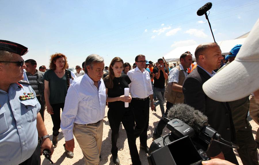 The U.N. refugee agency's special envoy, actress Angelina Jolie (C), Norwegian Foreign Minister Espen Barth Eide (5th L) and the U.N. High Commissioner for Refugees Antonio Guterres (3rd L) arrive at the Al Zaatri refugee camp, in the Jordanian city of Mafraq, near the border with Syria, June 20, 2013, the World Refugee Day. The refugee camp is hosting Syrians displaced by the country's domestic conflict. (Xinhua/Mohammad Abu Ghosh) 