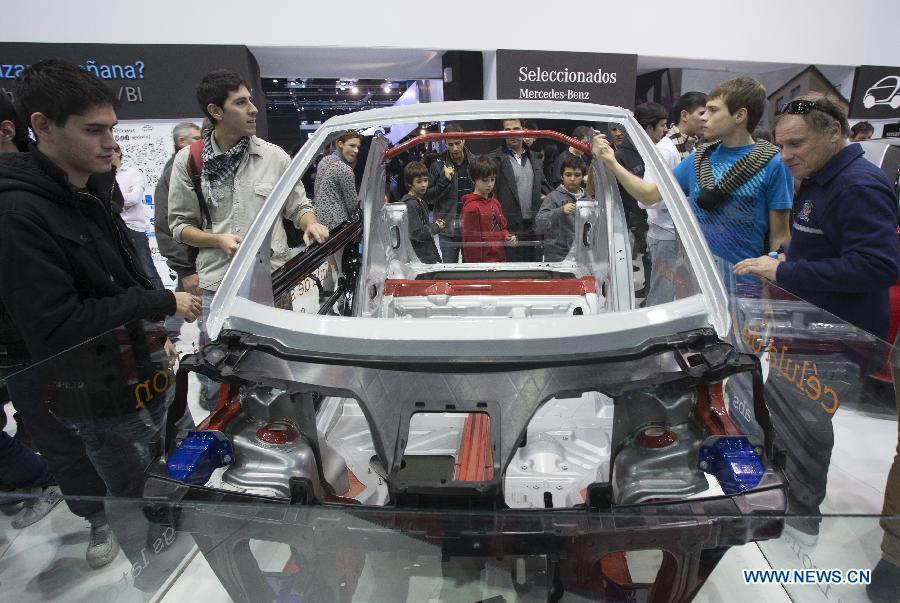 People observe the bodywork of a Mercedes Benz' Smart during the 6th International Auto Show, in the city of Buenos Aires, capital of Argentina, on June 21, 2013. (Xinhua/Martin Zabala)