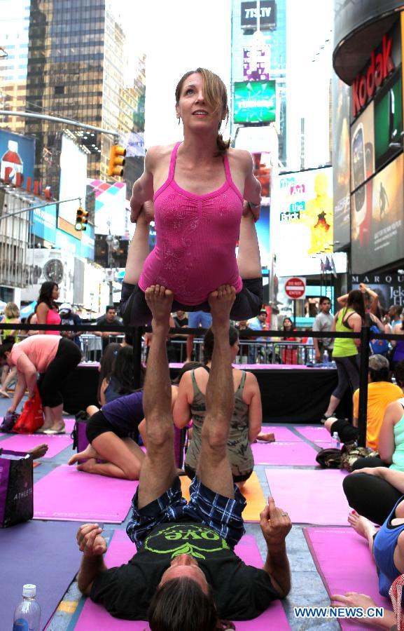 Yoga enthusiasts practice yoga during the "Solstice in Times Square" event at Times Square in New York, the United States, June 21, 2013. Thousands of yoga enthusiasts came here to do yoga in celebration of the longest day of the year. (Xinhua/Cheng Li) 