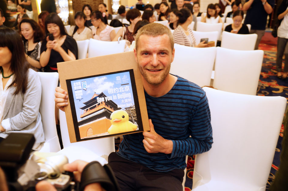 Dutch conceptual artist, Rubber Duck's "papa" Florentijin Hofman shows the present from Beijing Design Week (BJDW) organizer in press meeting in Beijing, June 22, 2013. As a special present given by BJDW's guest city Amsterdam, the Rubber Duck project will visit Beijing this September and stay for about one month. BJDW will be held from Sept. 26 to Oct. 3 in Beijing. (People's Daily Online/Chen Lidan)