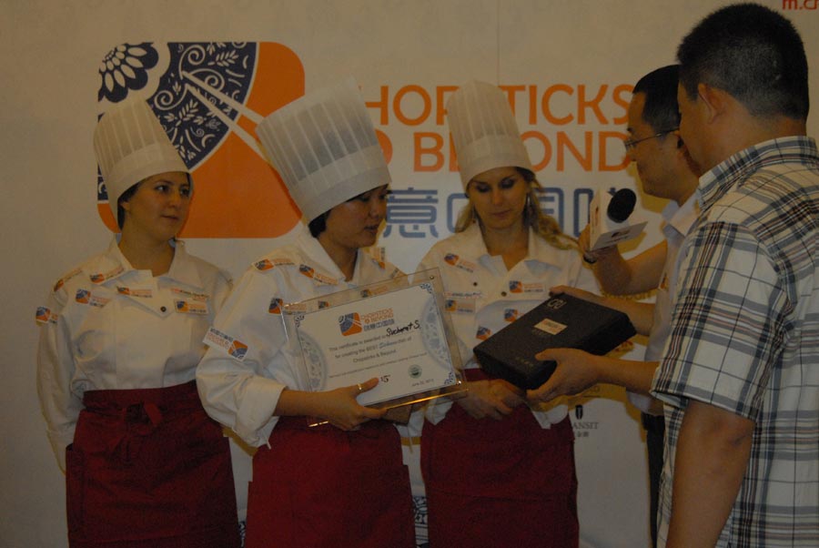 Winner Ying Si is awarded a certificate for creating a new, authentic Sichuan dish at "Chopsticks and Beyond", in Beijing, June 22, 2013. "Chopsticks and Beyond" is a Chinese cuisine challenge launched by CRIENGLISH.com to provide a platform for foreign food enthusiasts to show off their Chinese cooking skills and explore creative dishes with exotic flavor. It features China's four great traditions: Sichuan Cuisine, Cantonese Cuisine, Shandong Cuisine and Huaiyang Cuisine.(Xinhuanet/Yang Yi)