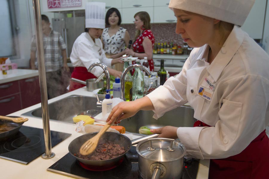 Contestant Alexandra Grillborzer from Germany, who is best in baking, prepares “Smashed Potato with Beef” at "Chopsticks and Beyond" Sichuan Cuisine Competition in Beijing, June 22, 2013. "Chopsticks and Beyond" is a Chinese cuisine challenge launched by CRIENGLISH.com to provide a platform for foreign food enthusiasts to show off their Chinese cooking skills and explore creative dishes with exotic flavor. It features China's four great traditions: Sichuan Cuisine, Cantonese Cuisine, Shandong Cuisine and Huaiyang Cuisine.(Xinhuanet/Yang Yi)