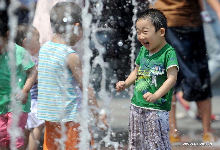 Children frolic at a fountain in Shenyang, capital of northeast China's Liaoning Province, June 23, 2013. (Xinhua/Zhang Wenkui)