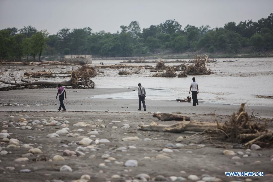 People walk on the bank of the Ganges River in Haridwar, northern Indian state of Uttarakhand, June 25, 2013. The heaviest monsoon rains in the state for the past 60 years, which trigered deadly floods in northern India, has claimed up to 807 lives, according to Indian Authorities on Tuesday. (Xinhua/Zheng Huansong) 