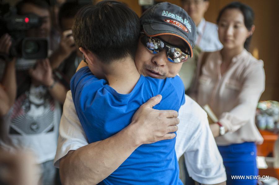 Survivor of a terror attack Zhang Jingchuan hugs his son after arriving at the airport in Kunming, capital of southwest China's Yunnan Province, June 26, 2013. Two Chinese mountaineers were among the victims killed in a pre-dawn terror attack in Pakistan-administered Kashmir on June 23. (Xinhua/Zhang Keren)  