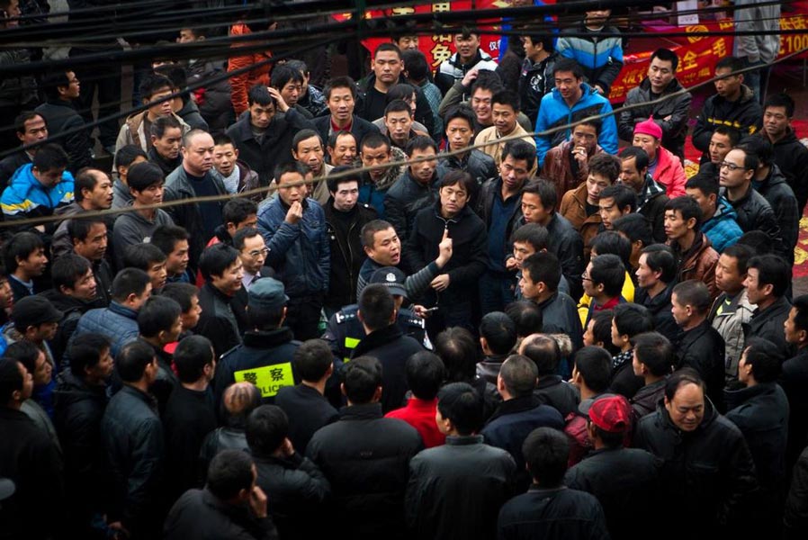 Job seekers quarrel outside a job agency in Wenzhou city, attracting a crowd of people around them on Jan 29, 2012. (Photo/CNTV)