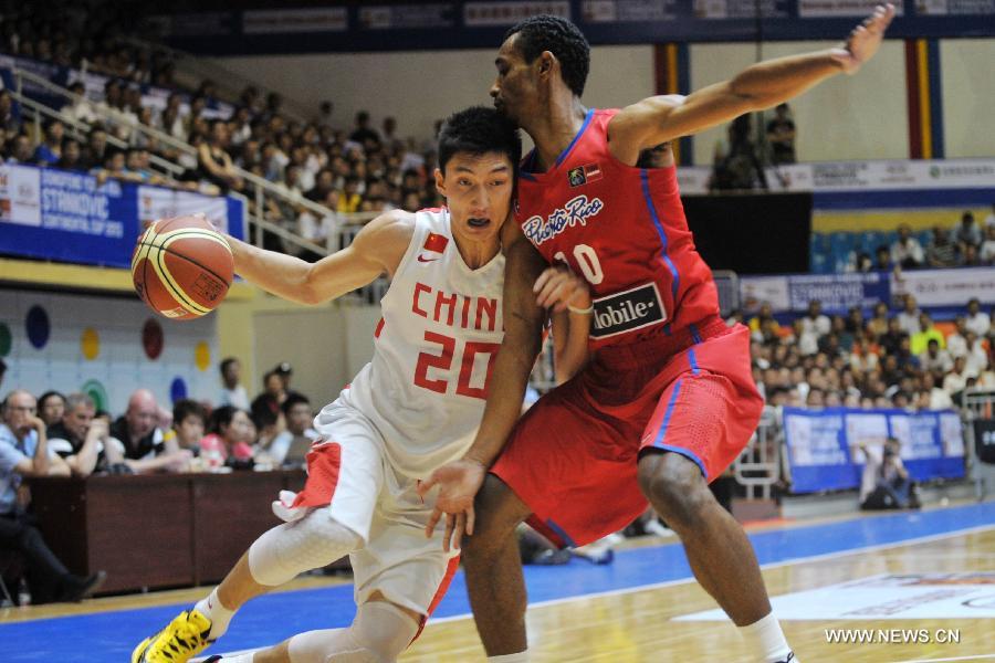 Makan Kelanbaike (L) of China drives the ball during a match against Puerto Rico at the Stankovic Continental Cup 2013 in Lanzhou, northwest China's Gansu Province, June 27, 2013. China won the match 79-67. (Xinhua/Chen Bin)