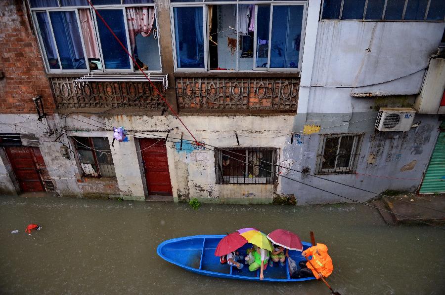 Residents are transferred by taking a boat on a flooded road in Nanchang, capital of east China's Jiangxi Province, June 28, 2013. Heavy rainfall hit the city on Friday. (Xinhua/Zhou Mi) 