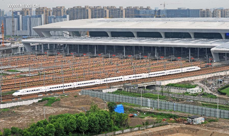 A bullet train on its trial trip enters the Hangzhou East Station in Hangzhou City, capital of east China's Zhejiang Province, June 30, 2013. A new high-speed railway that stretches across east China's Yangtze River Delta is scheduled to go into commercial service on July 1. The Nanjing-Hangzhou-Ningbo high-speed railway, with a designated top speed of 350 km per hour, will cut travel time between Nanjing, capital of east China's Jiangsu Province, and the port city of Ningbo in east China's Zhejiang Province to about two hours. High-speed trains will run at a speed of 300 km per hour during the initial operation period. (Xinhua/Tan Jin)