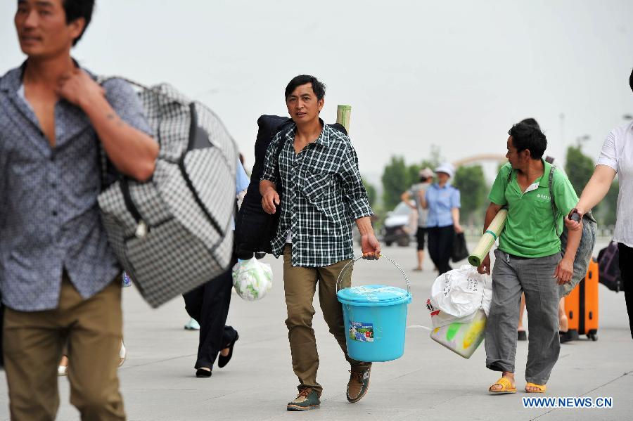 Passenger arrive at the Yinchuan Railway Station in Yinchuan, capital of northwest China's Ningxia Hui Autonomous Region, July 1, 2013. China's summer railway travel rush started on Monday and will last until Aug. 31. (Xinhua/Peng Zhaozhi) 