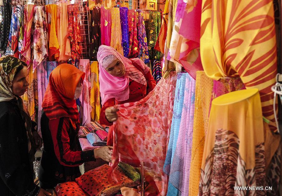 Women select clothes at Kashi Grand Bazzar in Kashi Prefecture, northwest China's Xinjiang Uygur Autonomous Region, June 30, 2013. Kashi Grand Bazzar is the largest international business market in China's northwest region. Bazzar in Uygur language means market or fair. (Xinhua/Shen Qiao)