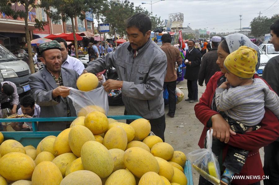 Locals buy melons at the Id Kah Bazaar in the city of Hotan, northwest China's Xinjiang Uygur Autonomous Region, July 1, 2013. (Xinhua/Zhao Ge)