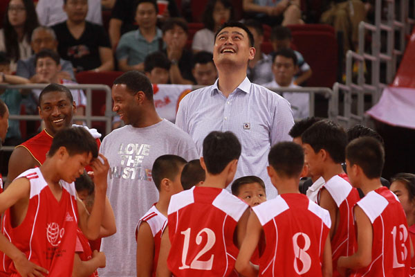 NBA star Tracy McGrady, back second left, stands beside his former Houston Rockets' teammate Yao Ming, back center, and others at a charity basketball game organized by the Yao Foundation in Beijing, July 1, 2013.(chinadaily.com.cn/Cui Meng)