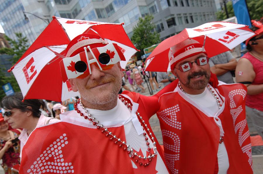 People participate in the Canada Day celebrations in Vancouver, Canada, on July 1, 2013. Tens of thousands of spectators flooded the streets of Vancouver to participate in Canada Day festivities. (Xinhua/Sergei Bachlakov) 