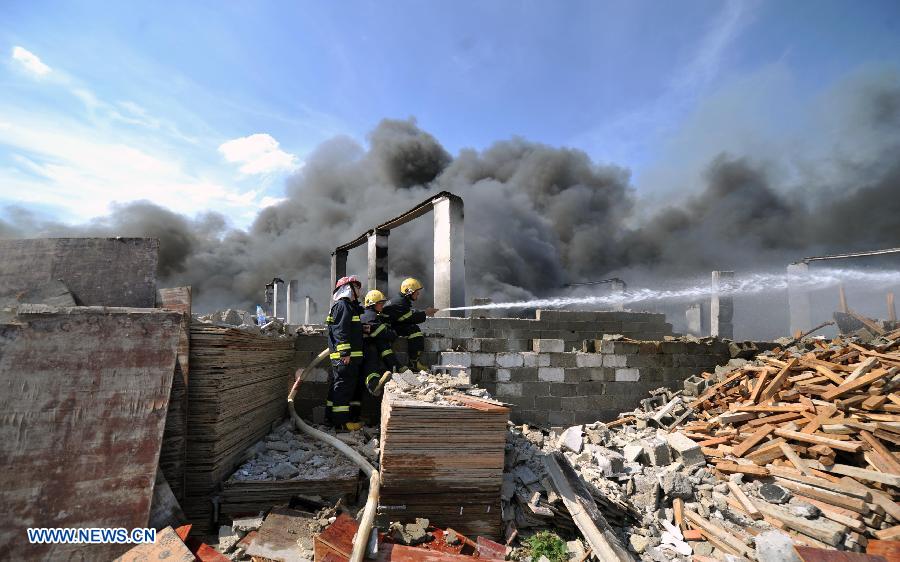 Firemen spray water to control a fire at a warehouse near the Changsha South Railway Station in Changsha, capital of central China's Hunan Province, July 2, 2013. A fire engulfed the warehouse Sunday without injuring anyone. Local fire department took more than two hours to douse the fire. (Xinhua/Li Ga) 