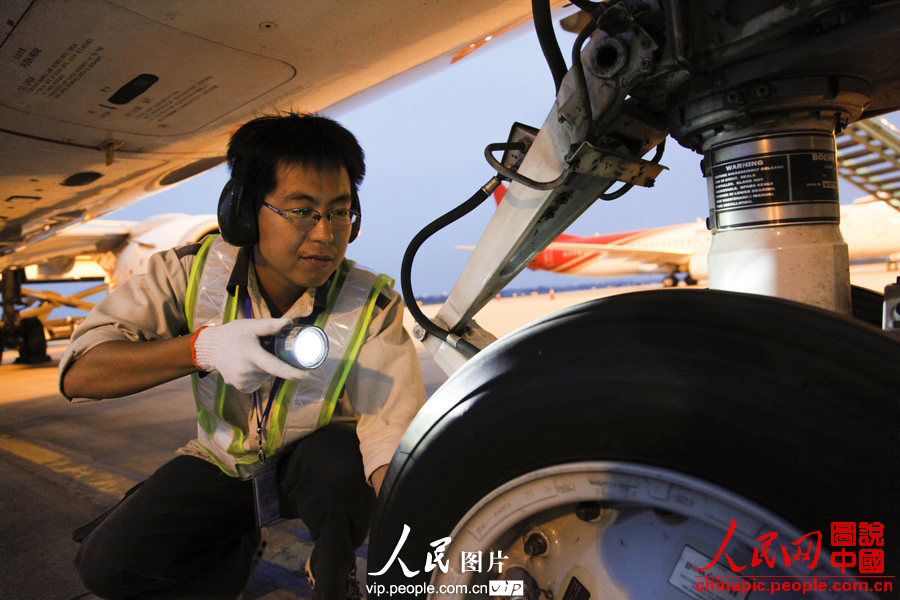 Wang Jin checks the tire of a plane. (Photo:Wang Yu/vip.people.com.cn)