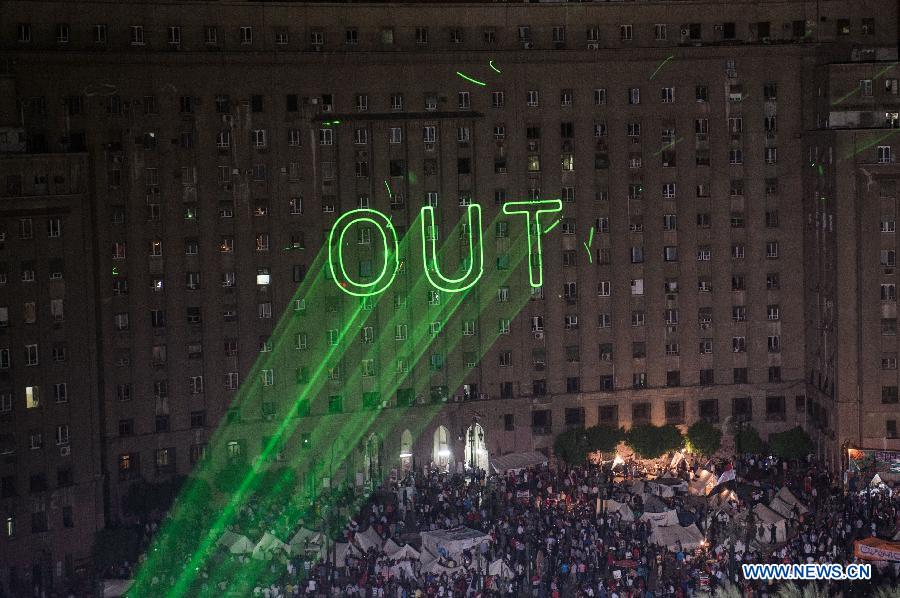 A laser projector makes "OUT" on a building near Cairo's Tahrir Square, Egypt, July 2, 2013. Egyptian President Mohamed Morsi said late Tuesday that there will be no alternative for "constitutional legitimacy," amid the ongoing political division in his country, where the opposition and liberal are asking him to quit power. (Xinhua/Li Muzi)