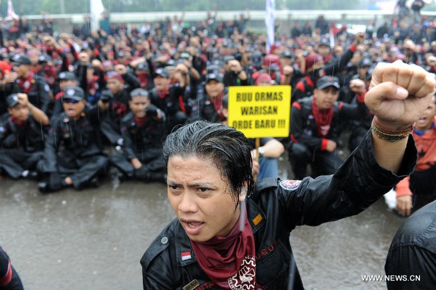 Protesters rally in front of the parlimentary house to refuse mass organization bill which will become law in Jakarta, capital of Indonesia, on July 2, 2013. Workers believe the mass organization bill will suppress freedom of association for all citizens.(Xinhua/Veri Sanovri)