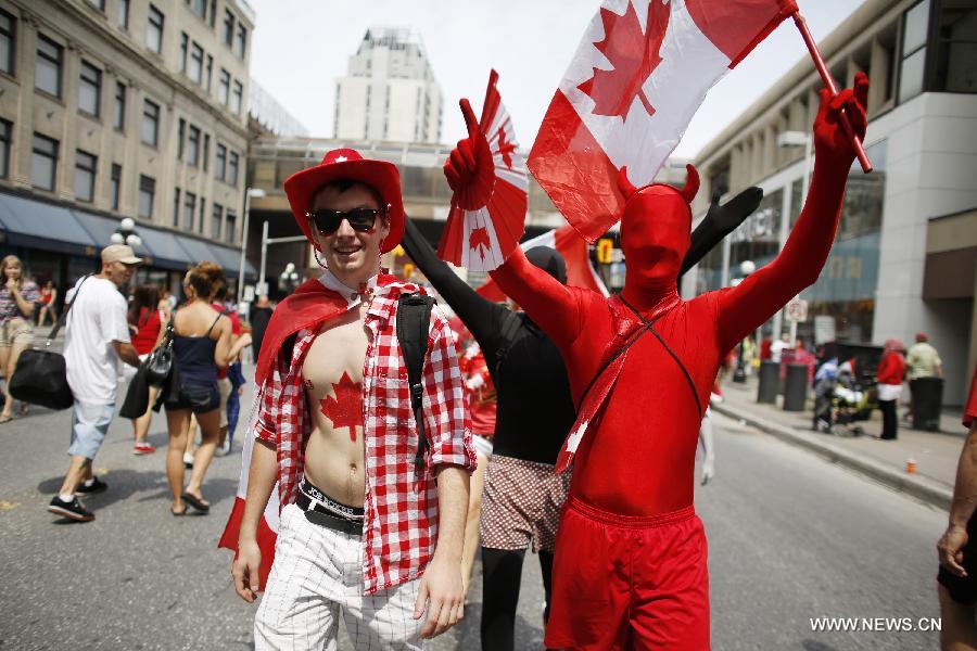 People attend a parade as a part of Canada Day celebrations in Ottawa, capital of Canada, on July 1, 2013. Celebrations were held across the country to mark the 146th anniversary of Canada's foundation. (Xinhua/David Kawai) 