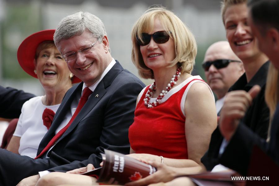 Canada's Prime Minister Stephen Harper (2nd L) and his wife Laureen react during the annual free concert, a part of Canada Day celebrations, in front of Parliament Hill in Ottawa, capital of Canada, on July 1, 2013. Celebrations were held across the country to mark the 146th anniversary of Canada's foundation. (Xinhua/David Kawai) 