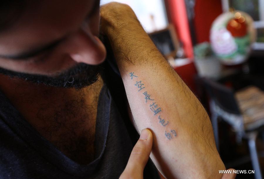 Juan Gonzalez Zamora shows his tattoo reading "The sky is blue" on his arm in Beijing, capital of China, July 2, 2013. (Xinhua/Zhang Chuanqi)