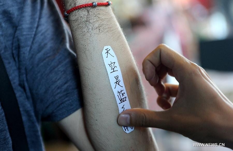 Chen Gong prepares to make a tattoo on Juan Gonzalez Zamora's arm in Beijing, capital of China, July 2, 2013. (Xinhua/Zhang Chuanqi)