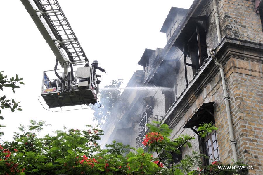 Firefighters try to put out a fire caused by short circuit in Ballard Pier Estate Exchange building, Mumbai, India, on July 3, 2013. The big fire, which broke out on Wednesday morning in a government building in south Mumbai, is under control. (Xinhua/Wang Ping)