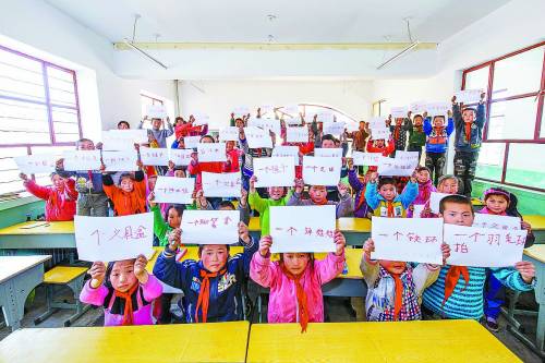 Students write their wishes on paper for the coming Children's Day. Now their wishes have been realized thanks to the help of the netizens. (Photo/China Youth Daily)