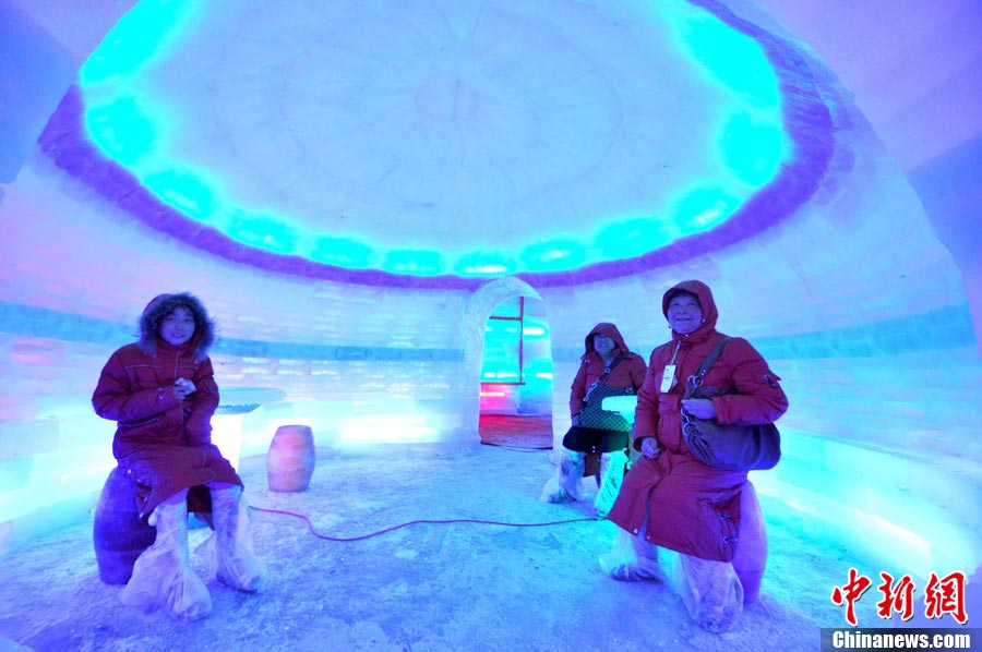 Tourists visit an ice sculpture exhibition in north China’s Hebei province to experience winter in summer on July 1, 2013. (Photo/CNS) 