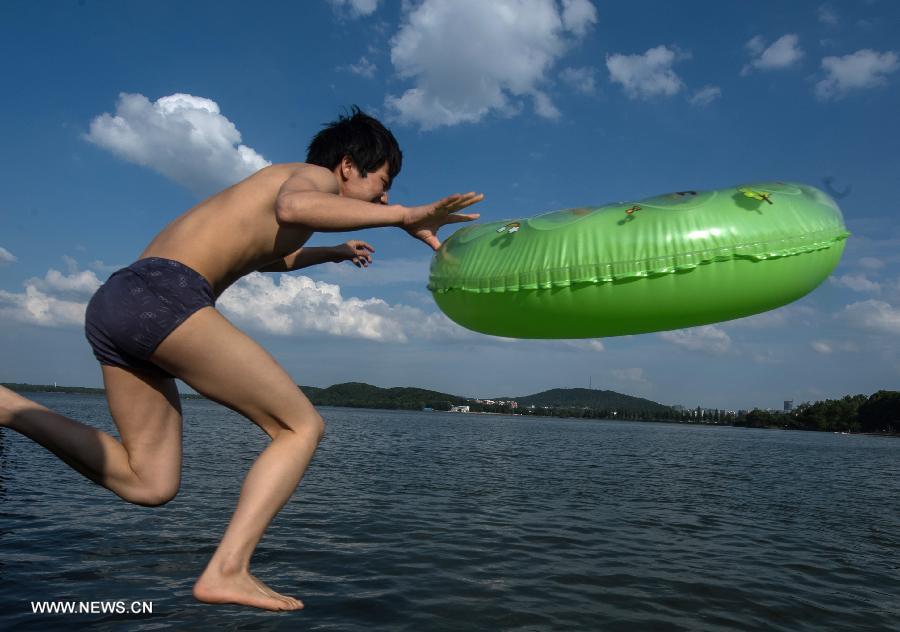 A man jumps into the water at the East Lake in Wuhan, capital of central China's Hubei Province, July 3, 2013. The highest temperature in Wuhan reached 36 degrees celsius on that day. (Xinhua/Cheng Min)