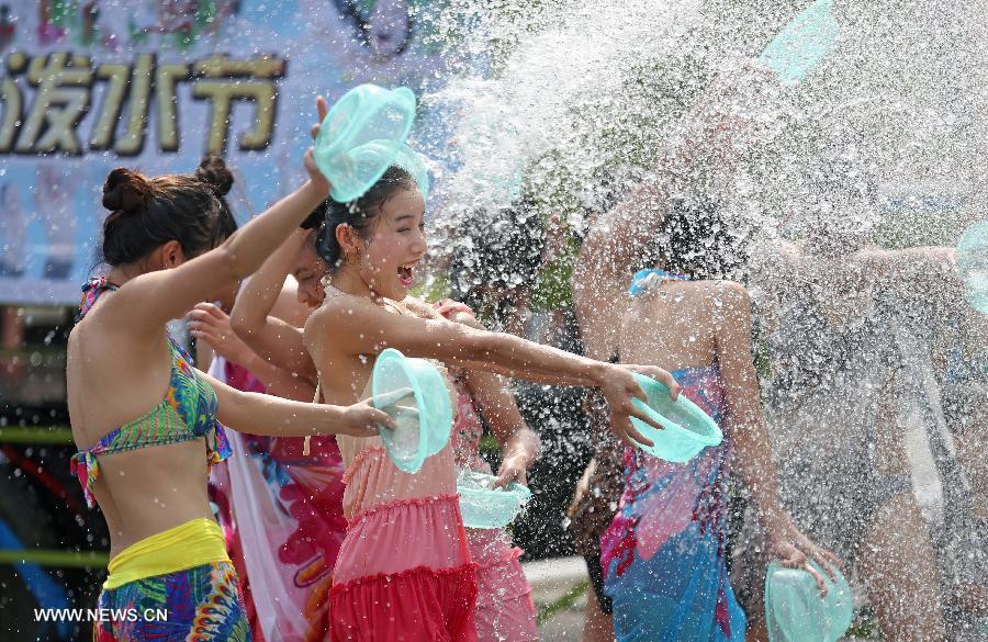 People attend a water-splashing festival during the summer at the Colorful World in  central China's city Changsha on June 29, 2013. (Xinhua/Li Ga) 