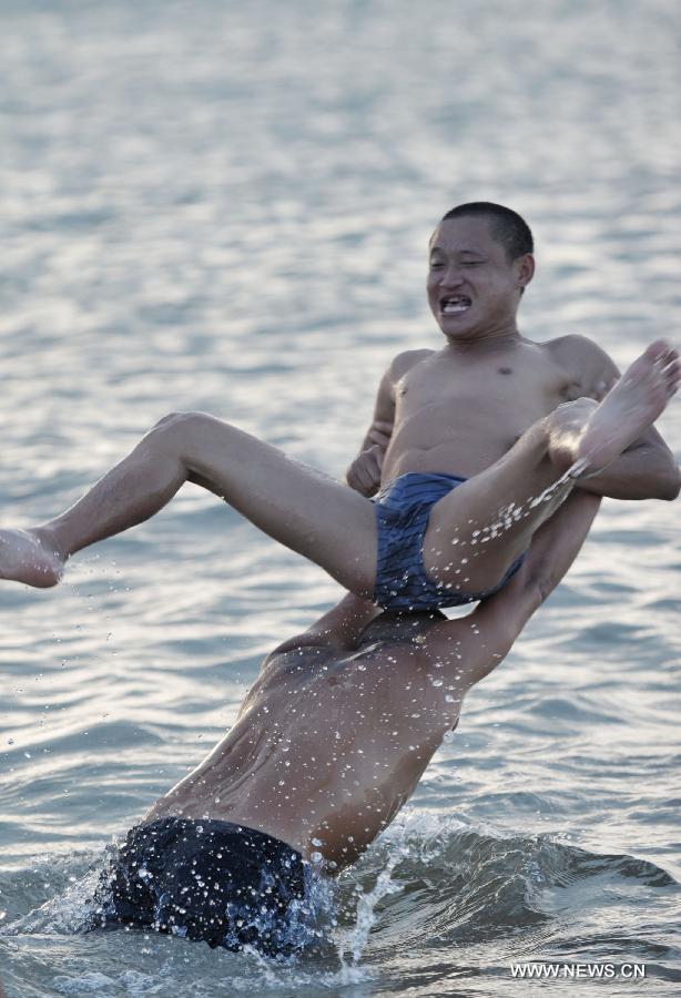 People play in the sea near Haikou, capital of south China's Hainan Province, June 29, 2013. The highest temperature in Haikou reached 35 degree centigrade, driving local residents to the seashore. (Xinhua/Zhao Yingquan)