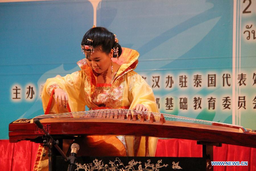 A Thai student plays Guzheng, a traditional Chinese musical instrument, during the final round of the sixth "Chinese Bridge" language proficiency competition for middle school student in Bangkok, capital of Thailand, July 5, 2013. A total of 17 Thai middle school students from all over the nation competed in the final. (Xinhua/Li Li) 