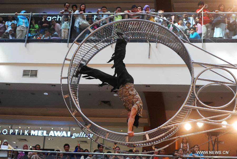 A member of acrobatic team from the USA performs "The wheel of death" at the Pondok Indah shopping mall in Jakarta, Indonesia, July 6, 2013. The acrobatic show lasts from June 21 to July 14. (Xinhua/Zulkarnain)