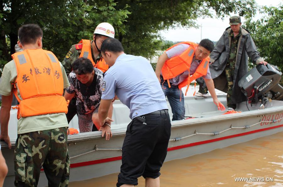 Rescuers evacuate a woman stranded by floods in Hebei Village, Qingyang County, east China's Anhui Province, July 6, 2013. Torrential rainfalls battered Anhui from July 4 to 6, and made some 30 counties in the province flooded. (Xinhua/Chen Jian) 