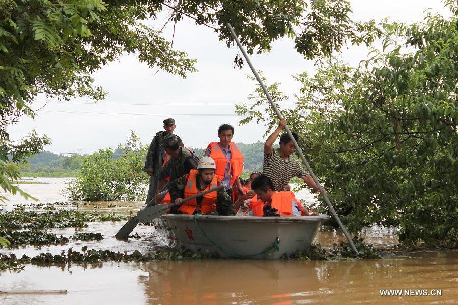Rescuers row a boat heading for the flooded Hebei Village, Qingyang County, east China's Anhui Province, July 6, 2013. Torrential rainfalls battered Anhui from July 4 to 6, and made some 30 counties in the province flooded. (Xinhua/Chen Jian) 