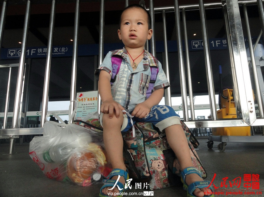 Child of migrant workers waits for the train at the Suzhou Railway Station in east China's Jiangsu province, July 1, 2013. (vip.people.com.cn/Wang Jiankang)