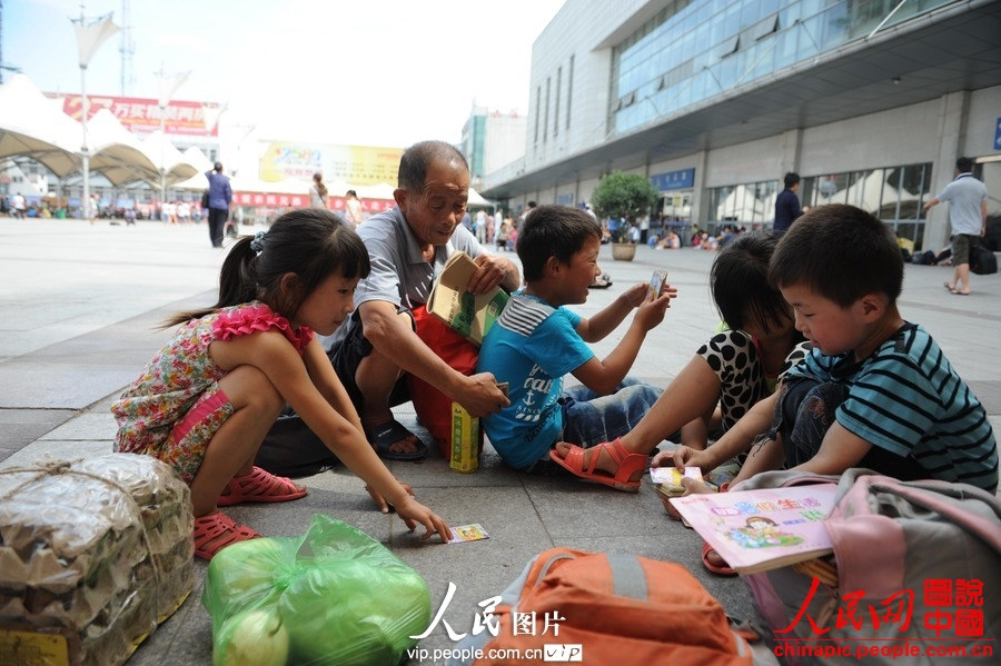 Several children accompanied by adults take the train to spend holidays with their parents working in cities at Fuyang Railway Station, east China's Anhui province, July 1, 2013. (photo/vip.people.com.cn)