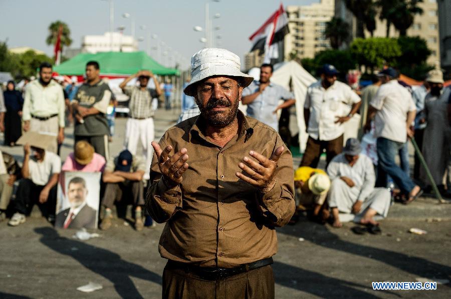 A supporter of ousted Egyptian president Mohamed Morsi prays outside the Republican Guards headquarters in Nasr city, Cairo, Egypt, July 6, 2013. (Xinhua/Li Muzi) 