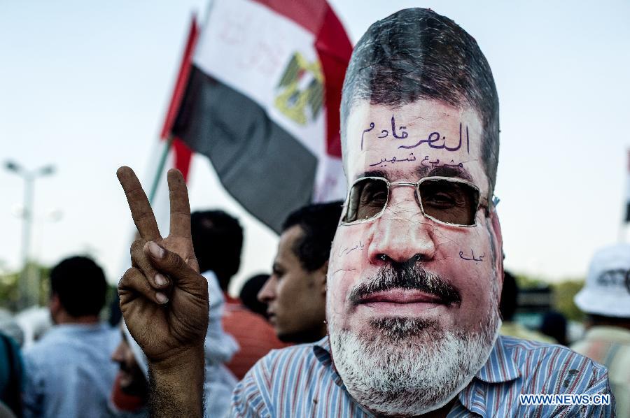 A supporter with ousted Egyptian president Mohamed Morsi's mask on his face protests outside the Republican Guards headquarters in Nasr city, Cairo, Egypt, July 6, 2013. (Xinhua/Li Muzi) 