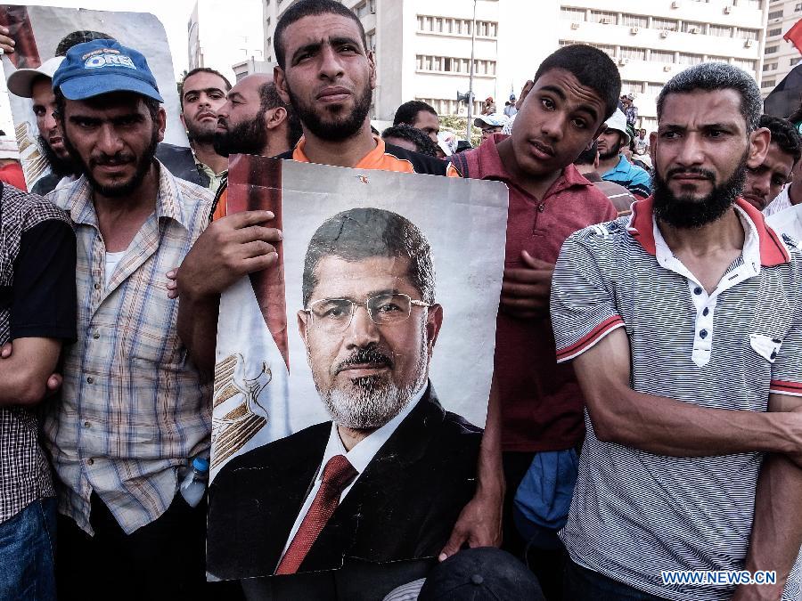 Supporters of ousted Egyptian president Mohamed Morsi holds a poster of Morsi as they protest outside the Republican Guards headquarters in Nasr city, Cairo, Egypt, July 6, 2013. (Xinhua/Li Muzi)