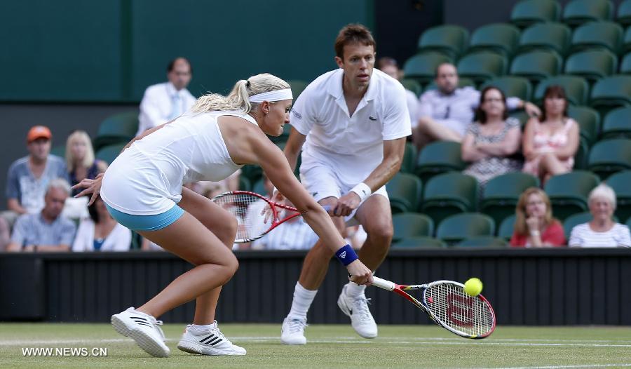 Daniel Nestor of Canada and Kristina Mladenovic (L) of France compete during the final of mixed doubles against Bruno Soares of Brazil and Lisa Raymond of the United States on day 13 of the Wimbledon Lawn Tennis Championships at the All England Lawn Tennis and Croquet Club in London, Britain, on July 7, 2013. Daniel Nestor and Kristina Mladenovic claimed the title with 2-1. (Xinhua/Wang Lili)