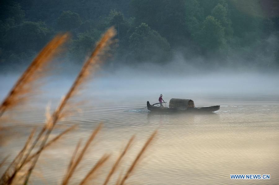 A fisherman fishes on the Xiaodongjiang River in Zixing City, central China's Hunan Province, July 7, 2013. (Xinhua/He Maofeng)