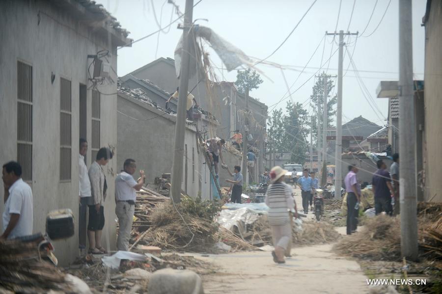 Villagers repair their houses damged by a tornado in Yuhu Village, Gaoyou City, east China's Jiangsu Province, July 8, 2013. Tornados battered Gaoyou and Yizheng in the province on July 7, making houses and power devices damaged. (Xinhua/Meng Delong)